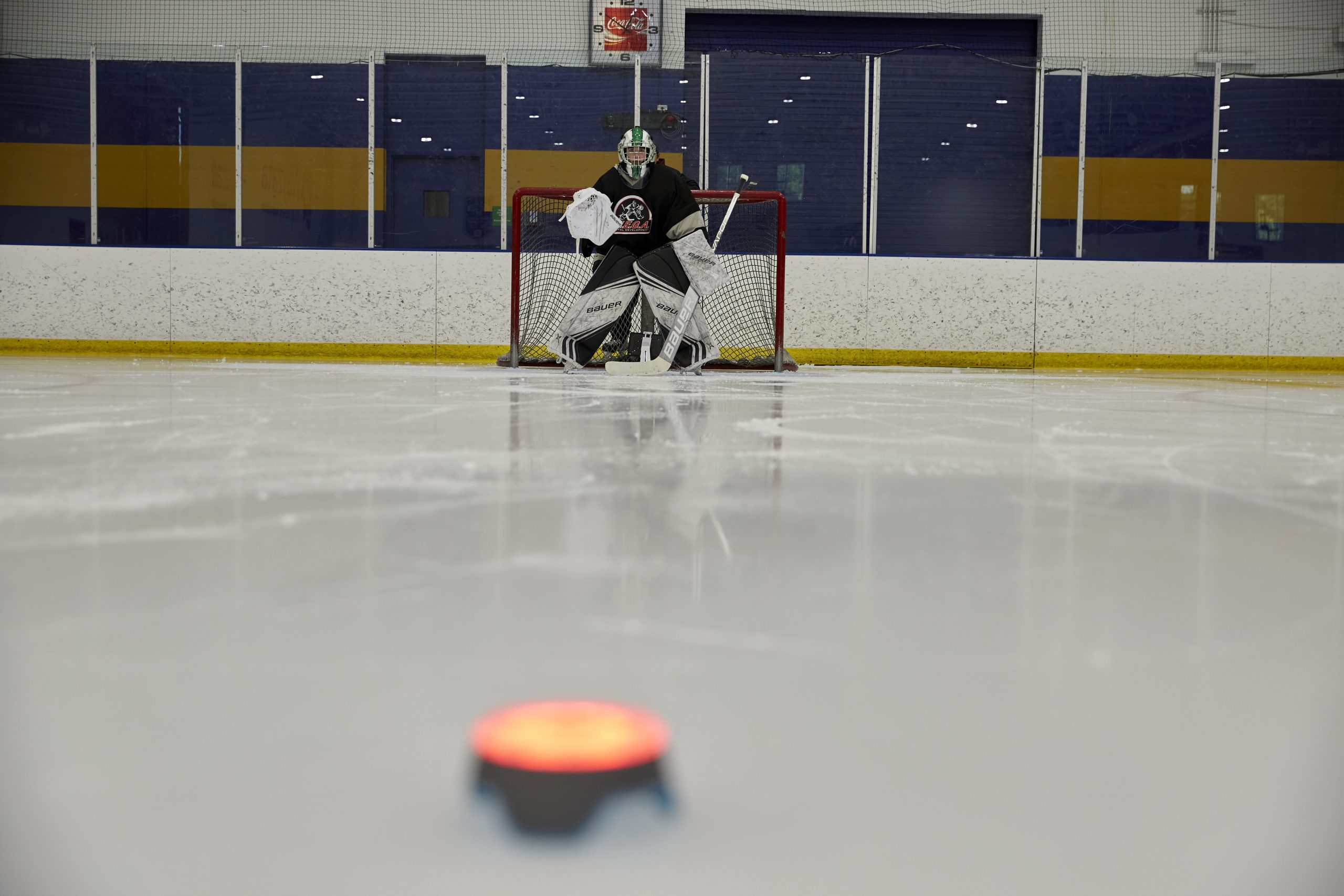 A hockey goalie in position in front of the net during a training exercise